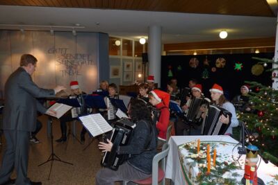 Orchester accordimento spielt im weihnachtlich geschmückten Foyer