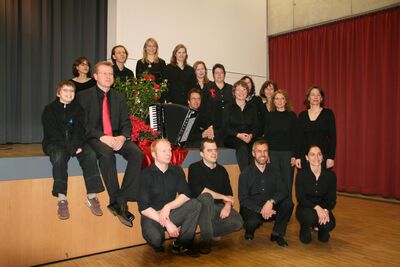 Gruppenbild: Dirigent und Orchester vor der Bühne